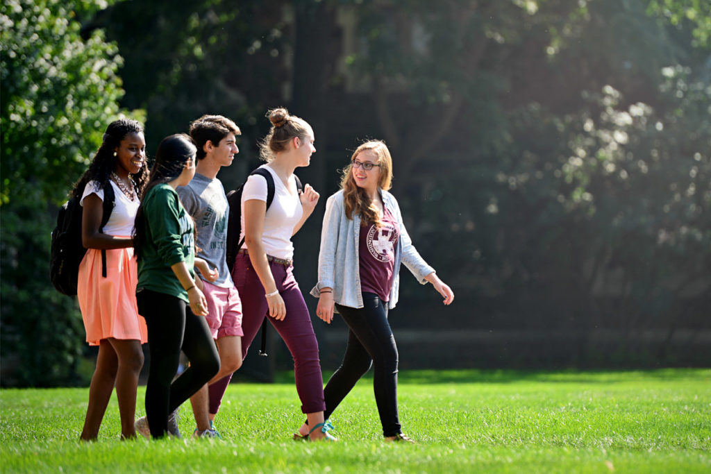group of students walking on campus in-line