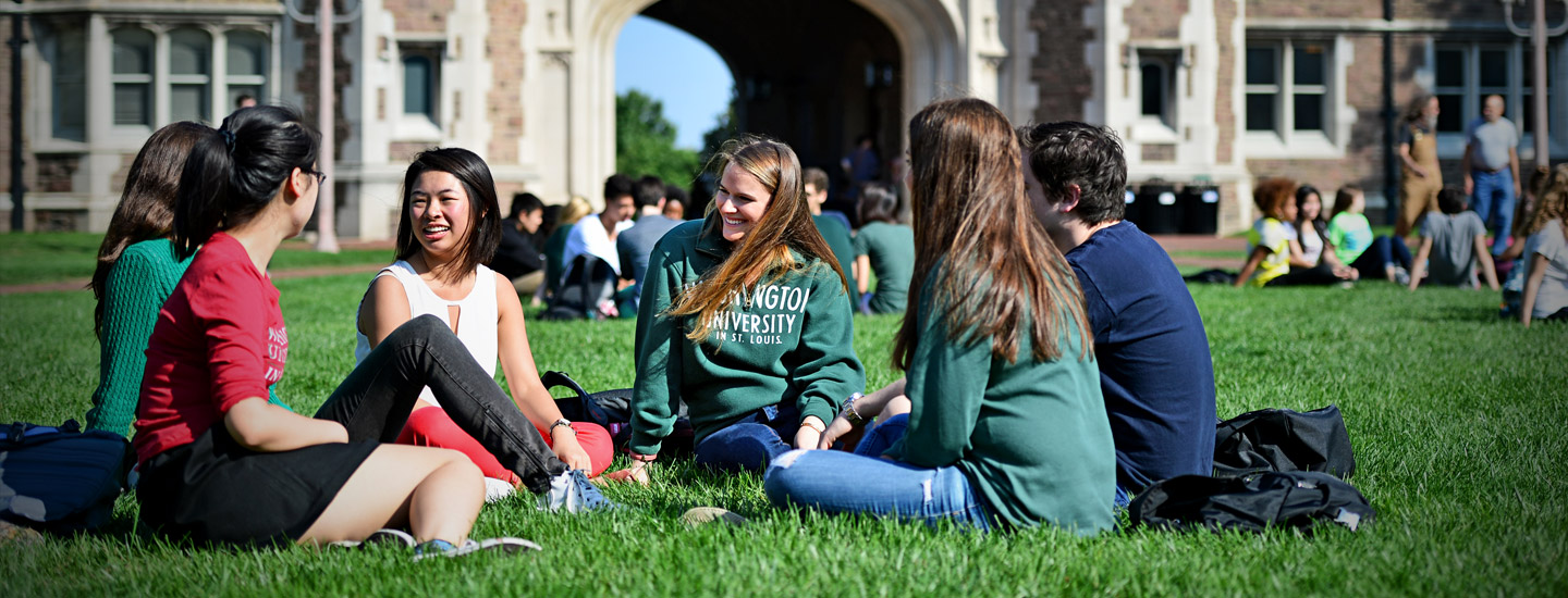 group of students sitting and talking on campus featured